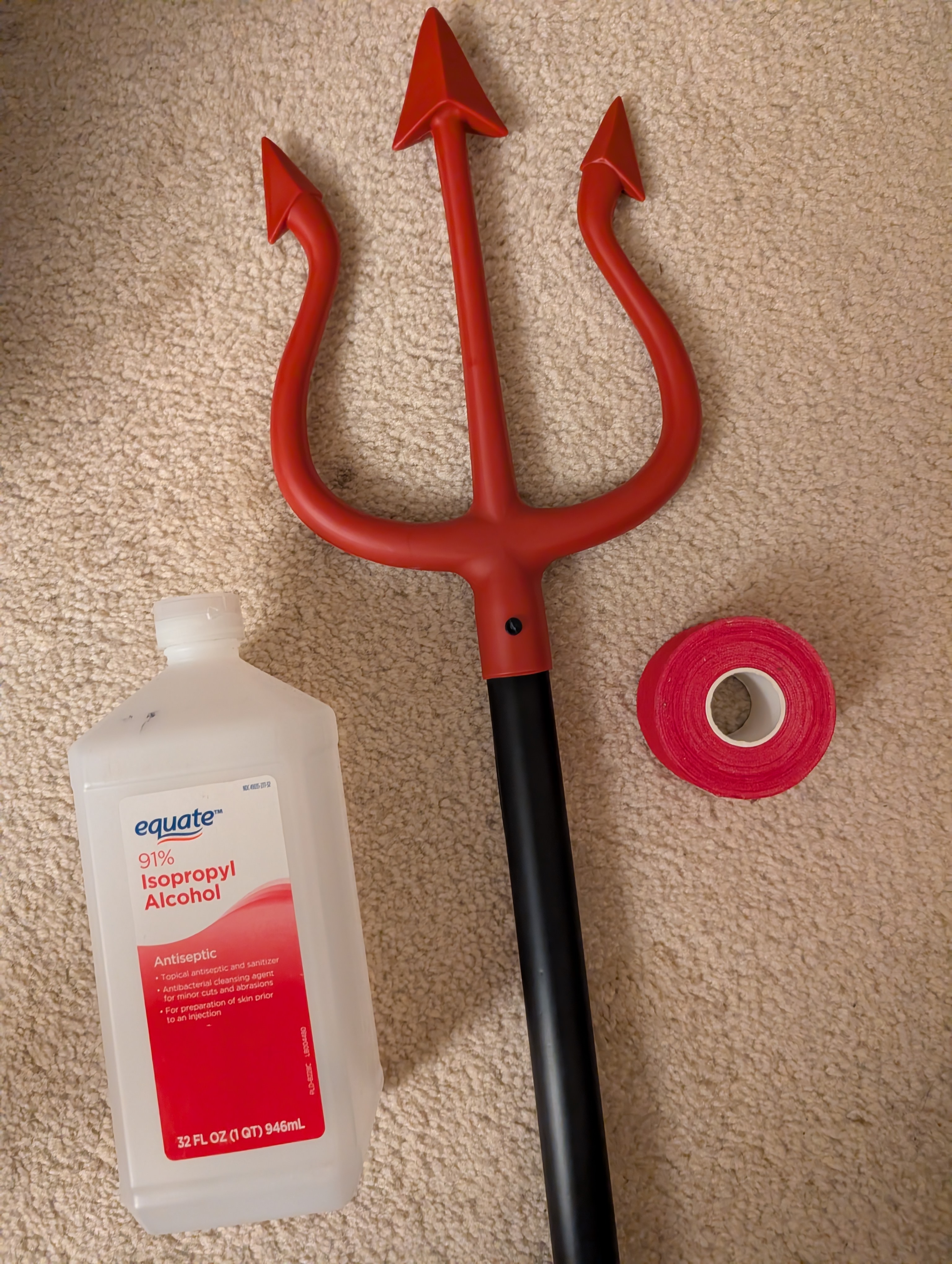 Materials for flaming devil's trident: plastic trident, bottle of
           isopropyl alcohol, and roll of red athletic tape